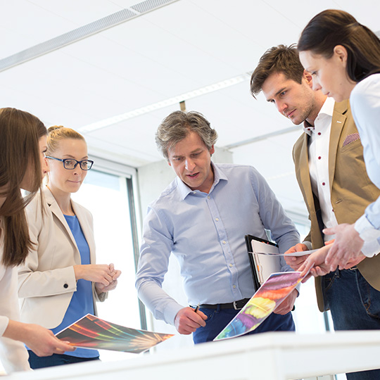 colleagues discussing colored printouts