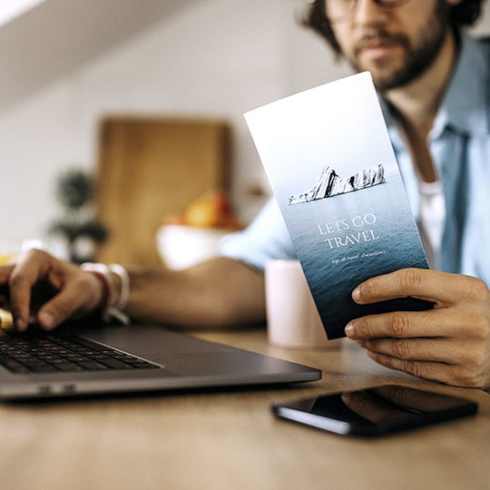 man with laptop and brochure