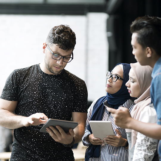 Man showing laptop to a group of people