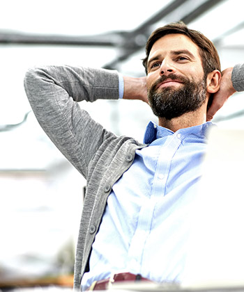 man with hands behind head