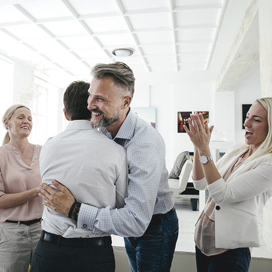 Coworkers congratulating colleague
