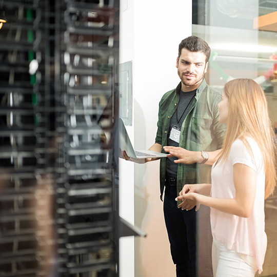 Man and woman in front of computer servers