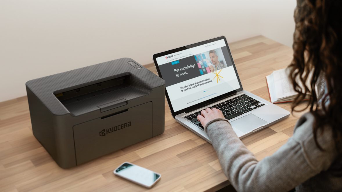 Kyocera redefines personal printing Woman with laptop and Kyocera's PA2000w printer