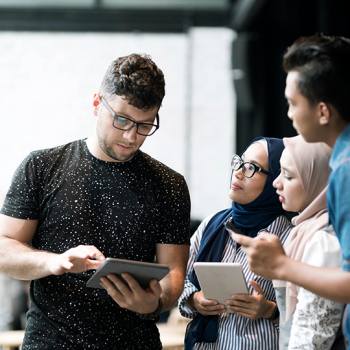 Man showing laptop to a group of people