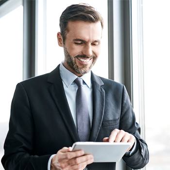 The New Normal: Remote Working man sitting in front of a laptop checking his phone